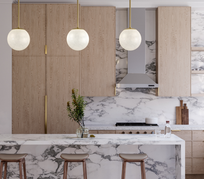 Marble kitchen island styled with three Burlington pendants installed above it.