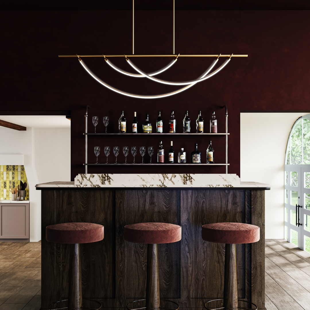 A dark moody bar styled with the linear Aryas in Vintage Brass over a marble island.