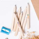 A collection of six short grey-lead pencils and a blue pencil sharpener on a white surface.