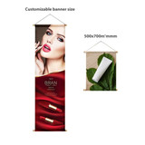 A hanging banner featuring a glamorous model with red lipstick on a red and gold background, and a white rolled-up banner. A hanging banner featuring a glamorous model with red lipstick on a red and gold background, and a white rolled-up banner.
