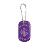 A purple dog tag with a decorative design and a silver chain. It features a logo and the text "MILITARY BRAT".
