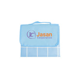 A large picnic blanket in blue featuring a grid pattern and a logo. Folds neatly with a carry handle. A large picnic blanket in blue featuring a grid pattern and a logo. Folds neatly with a carry handle.
