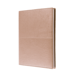 A A5 ruled notebook in a sleek rose gold finish with a subtle texture and a logo on the cover. A A5 ruled notebook in a sleek rose gold finish with a subtle texture and a logo on the cover.