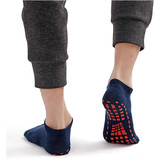 Low cut gripper socks in navy blue with a non-slip pattern on the sole, worn with grey joggers.