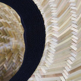 A straw hat featuring natural woven material and a black fabric band around the brim.