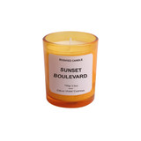 A 3.5oz glass candle in an orange holder, featuring a white label with the scent name and branding.