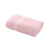A folded bamboo fibre towel in soft pink, featuring a textured design and a subtle strap.