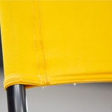A close-up of a bright yellow fabric detail attached to a black metal frame, showcasing stitching and texture.