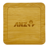 A bamboo coaster with a square shape, featuring an engraved logo. The colour is light brown.