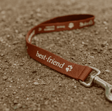 A brown dog leash with a metal clasp and a logo, featuring the text "best friend".