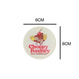 Acrylic fridge magnet featuring a playful design with a bakery theme, primarily in white, red, and brown.