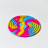 A circular sensory activity board featuring vibrant rainbow colours of pink, yellow, and blue.