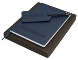 A navy travel journal set with a notebook and a matching luggage tag, presented in a dark box.