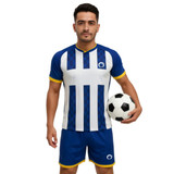 A man holds a soccer ball while wearing a blue and white striped athletic shirt with matching shorts.