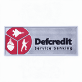 A moulded PVC bar mat featuring a grey background with red and black elements, including a logo and symbols of service.