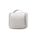 A hanging travel toiletry bag in light grey with a zip closure and a handle on top.
