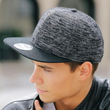 A black and grey cap with a textured design and a flat brim, featuring a logo on the front.