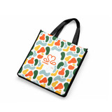 A vibrant tote bag featuring a multicoloured abstract pattern with green, orange, and yellow shapes. It has black handles and a logo.
