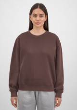 A brown crew sweatshirt for women, featuring a relaxed fit and long sleeves, displayed on a model.