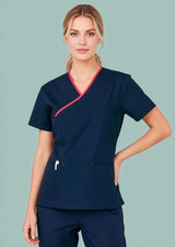 A women's scrub top in navy with contrast red detailing, featuring a crossover design and a logo.