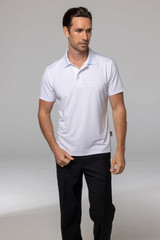 A white polo shirt modelled by a man, paired with black trousers, featuring a logo on the shirt.