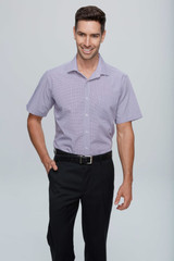A short sleeve button-up shirt in a light purple hue, presented on a model with a belt and dark trousers.