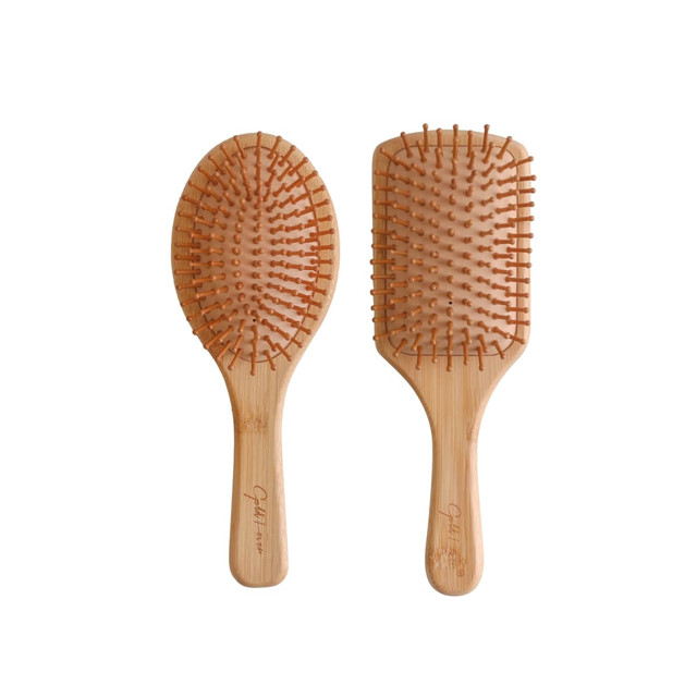 Two bamboo hair brushes with padded bases and wooden bristles, showcasing a natural, earthy aesthetic.