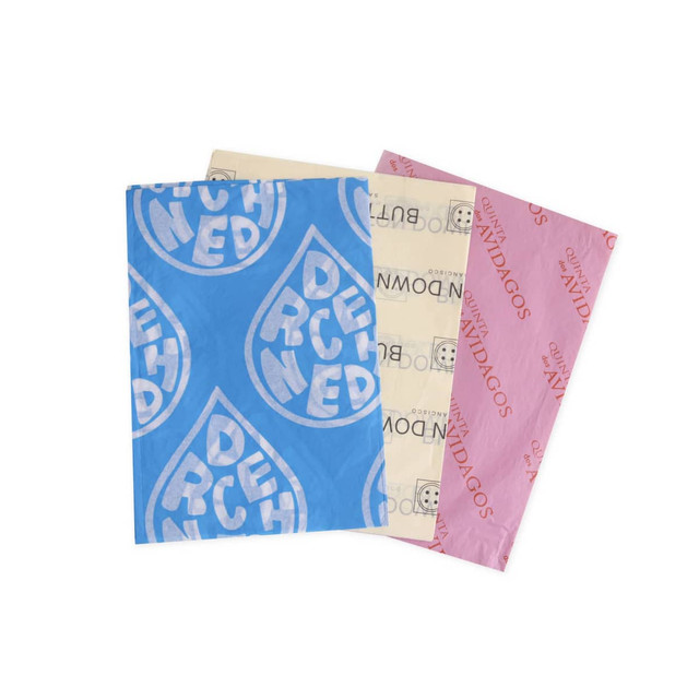 A stack of Kraft paper sheets in blue, cream, and pink, featuring various patterns and a logo.
