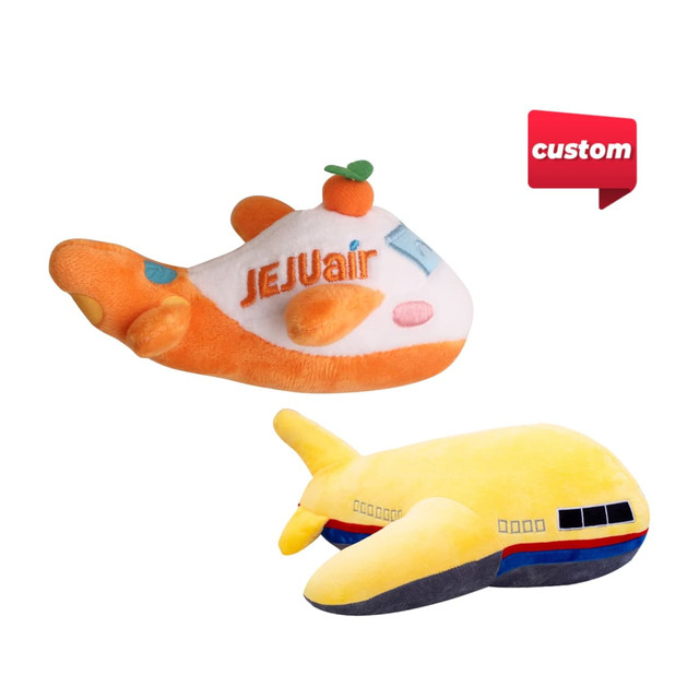 A plush toy shaped like an airplane, featuring orange and yellow colours with a logo. Ideal for fun and games.