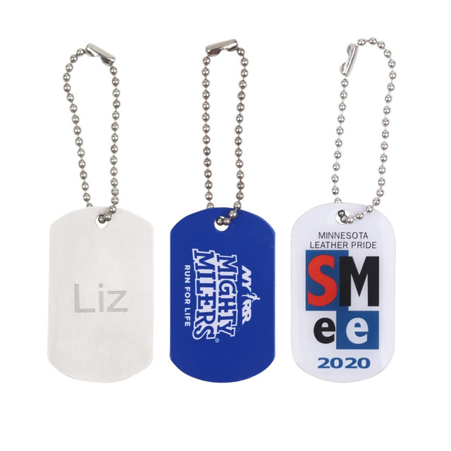 Three dog tags in silver, blue, and white, each with a chain attachment and various designs.