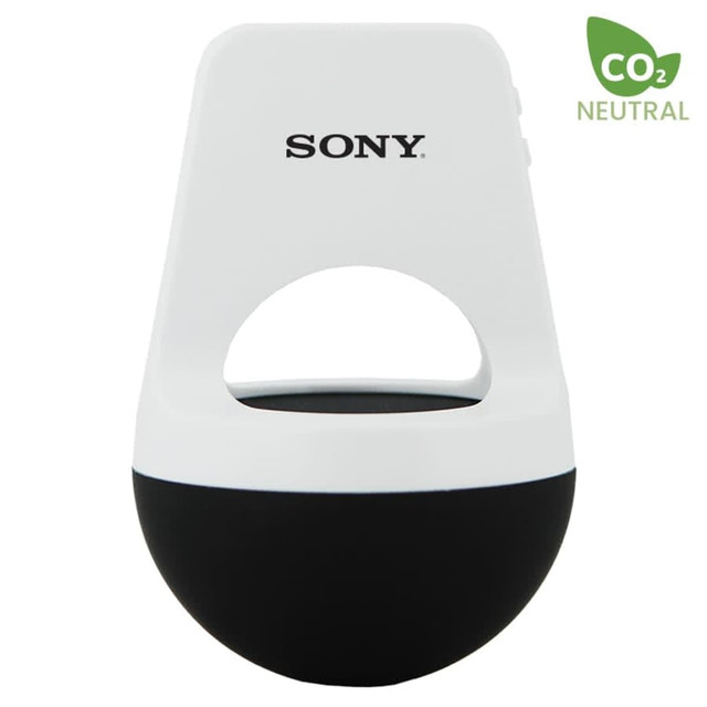 A white and black wireless speaker with a loop handle and logo branding. Compact and modern design.