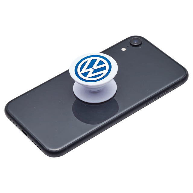 A white phone grip featuring a logo, placed on a black smartphone screen.