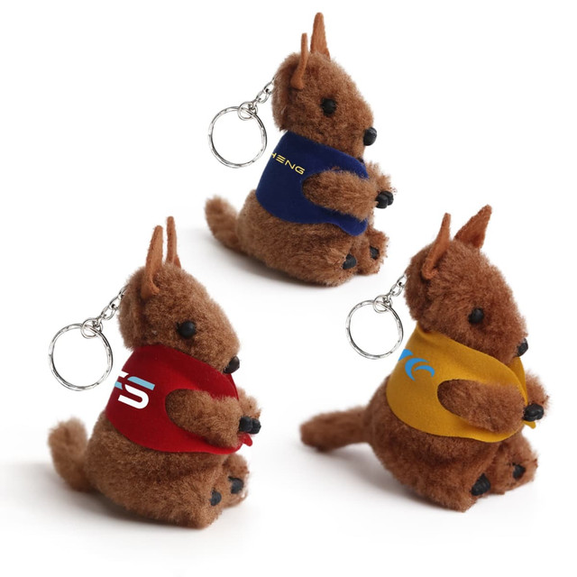Three kangaroo-shaped plush toys with keychains, featuring brown fur and colourful vests in red, blue, and yellow.