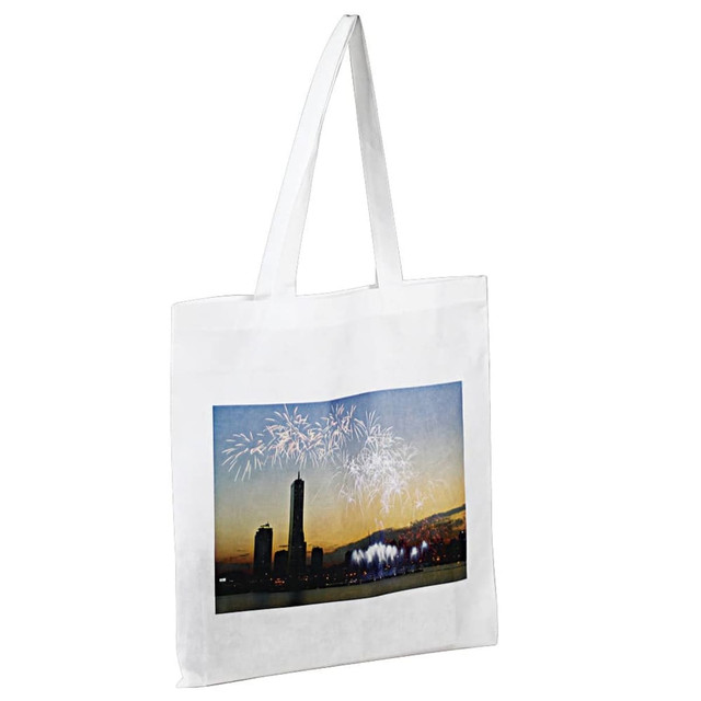 A white tote bag featuring a printed image of a city skyline with fireworks in the background. It has long handles. A white tote bag featuring a printed image of a city skyline with fireworks in the background. It has long handles.