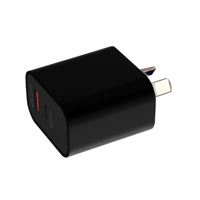 A black wall charger features a USB port and prongs for connecting to power outlets. It has branding on the side.