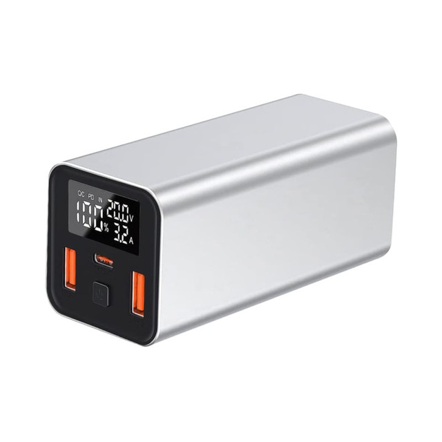 A silver power bank with two USB ports and a digital display, designed for laptops and devices.