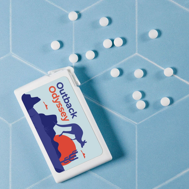 A rectangular white container of sugar-free breath mints with a colourful design, surrounded by white mints, on a blue background.