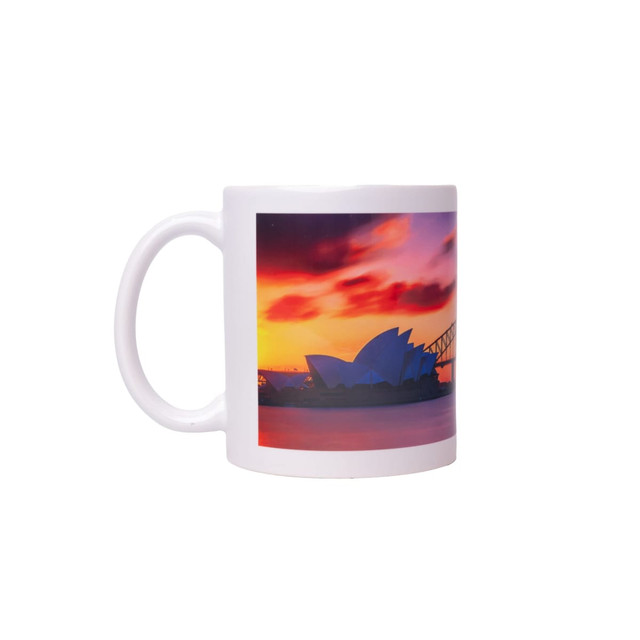 A white coffee mug featuring an image of the Sydney Opera House against a colourful sunset backdrop.