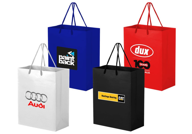 Large full coloured laminated bags in blue, red, white, and black with handles and various logos.