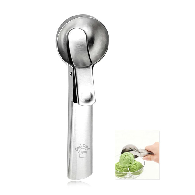 A stainless steel ice cream scoop with a lever mechanism, displayed beside a bowl of green ice cream.
