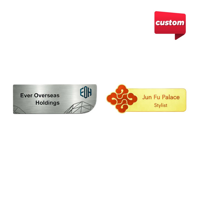 Two metal name badges in silver and gold, featuring a logo, with text for different organisations.