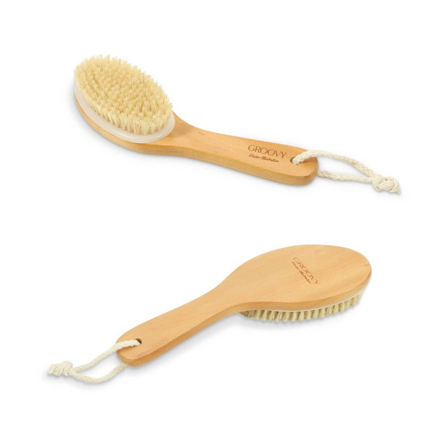 A wooden dry brushing body brush with natural bristles and a rope for hanging, featuring a light brown finish.