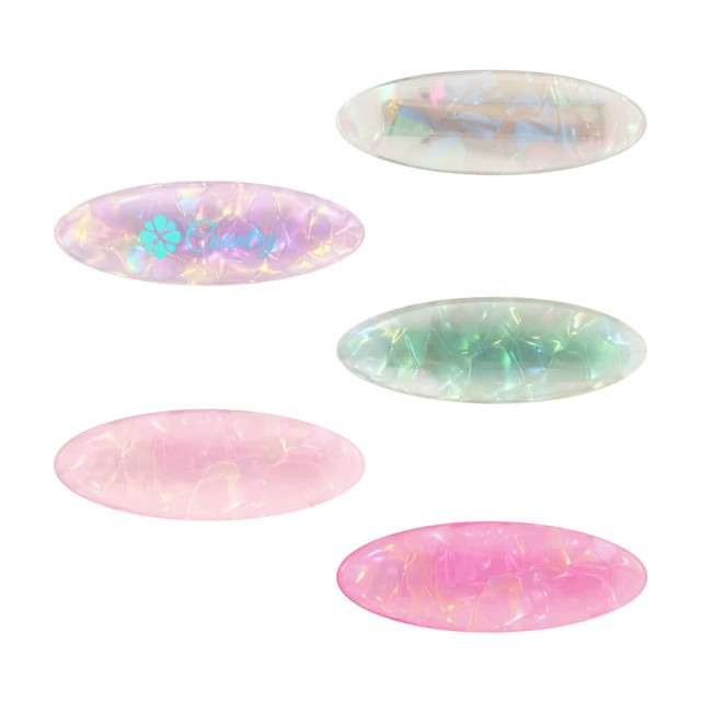 An assortment of oval iridescent alligator hair clips in pink, green, and transparent colours, featuring a logo on one.