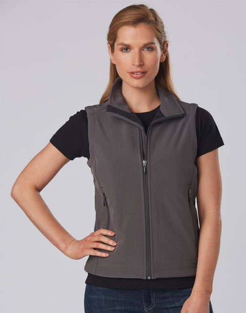 A grey ladies' softshell vest with a zip front and side pockets, worn over a black t-shirt. Features a logo.