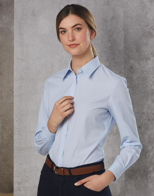A long sleeve button-up shirt in light blue, featuring a collar and a fitted design, paired with a brown belt.
