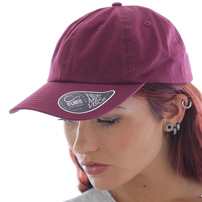 A maroon Dad Hat with a curved visor and a logo on the side, worn by a person with red hair.