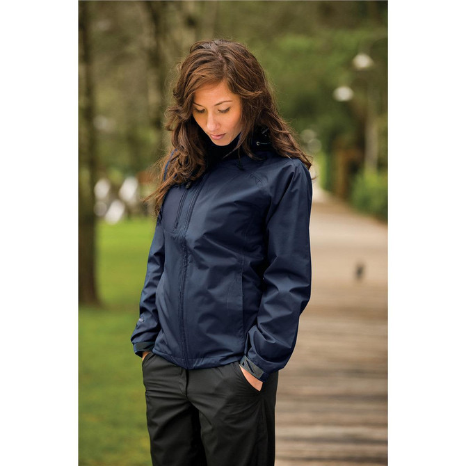 A navy rain jacket with a hood, featuring a logo, worn by a woman outdoors.