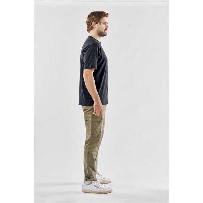 A black men's t-shirt displayed on a model standing sideways, wearing khaki cargo pants and sneakers.