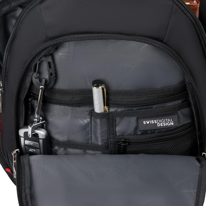An inner pocket of a black backpack featuring compartments for a pen, keys, and a small device.