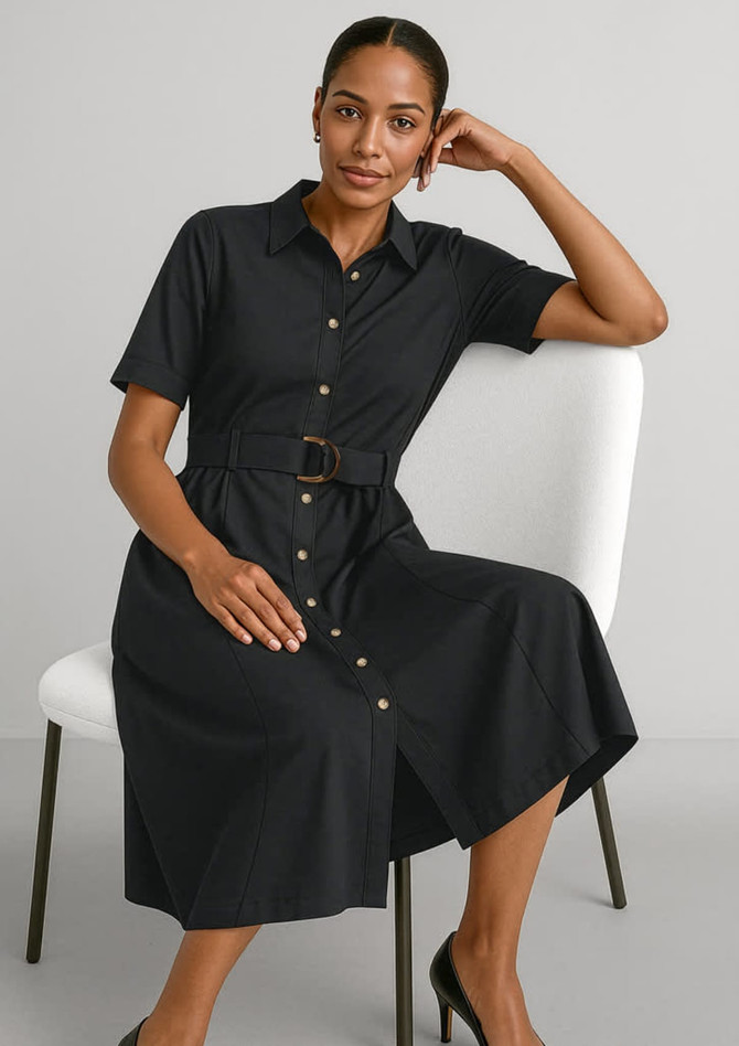 A black midi dress with short sleeves, a button-down front, and a belted waist, displayed on a seated model.